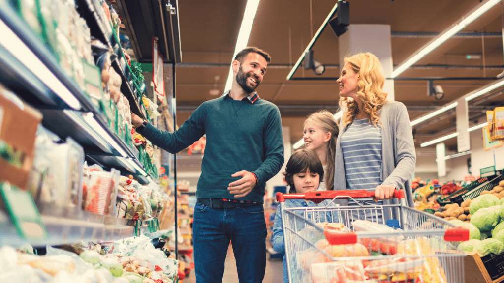 Family in supermarket looking happy in reduction of food prices